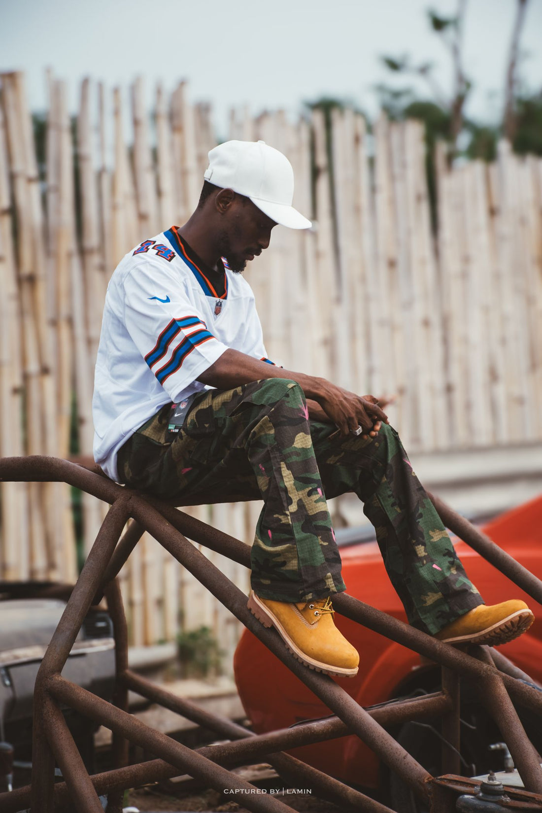 Streetwear model in camouflage pants and boots posing outdoors