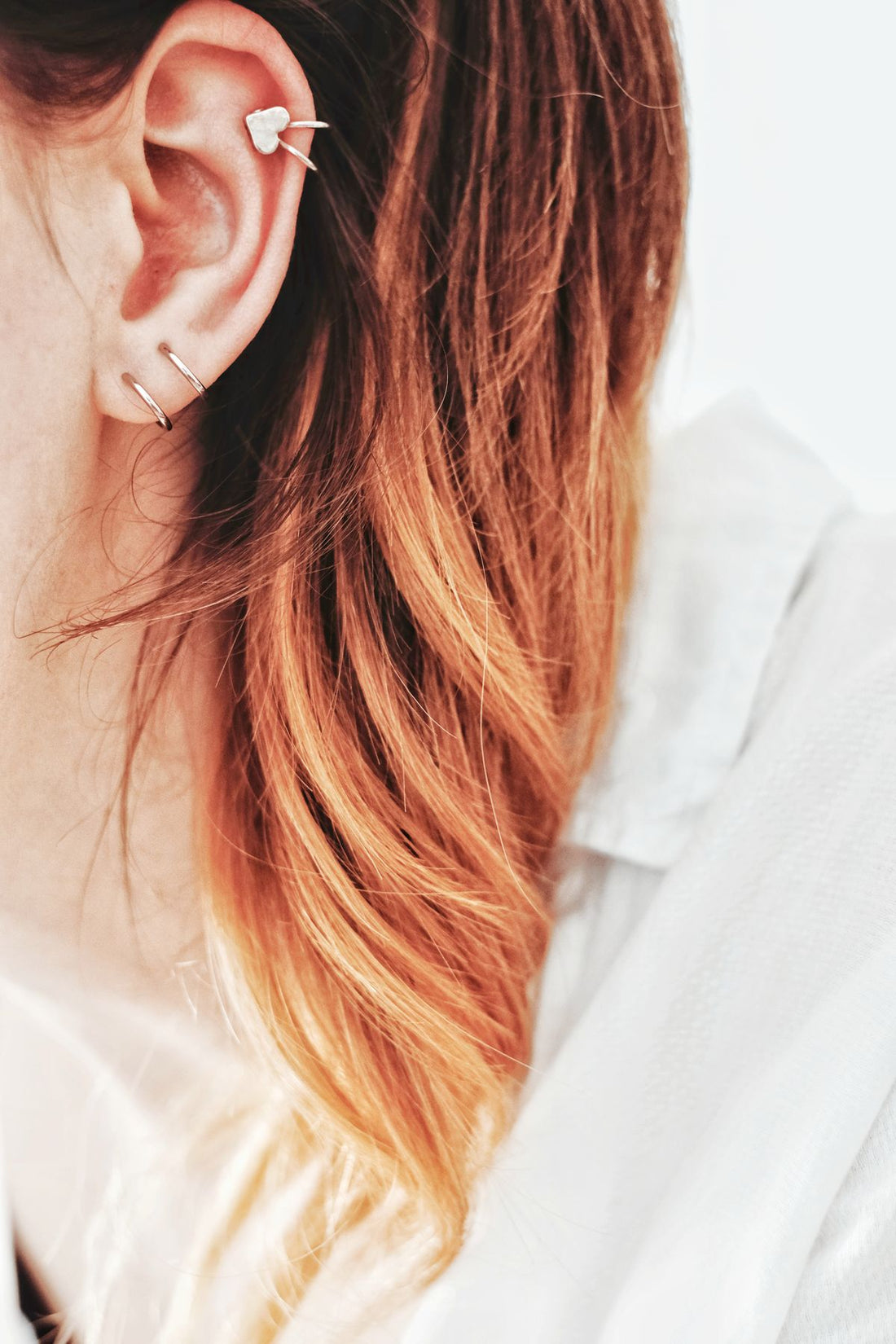 Close-up portrait of a model wearing eye-catching hoop earrings and charm jewelry