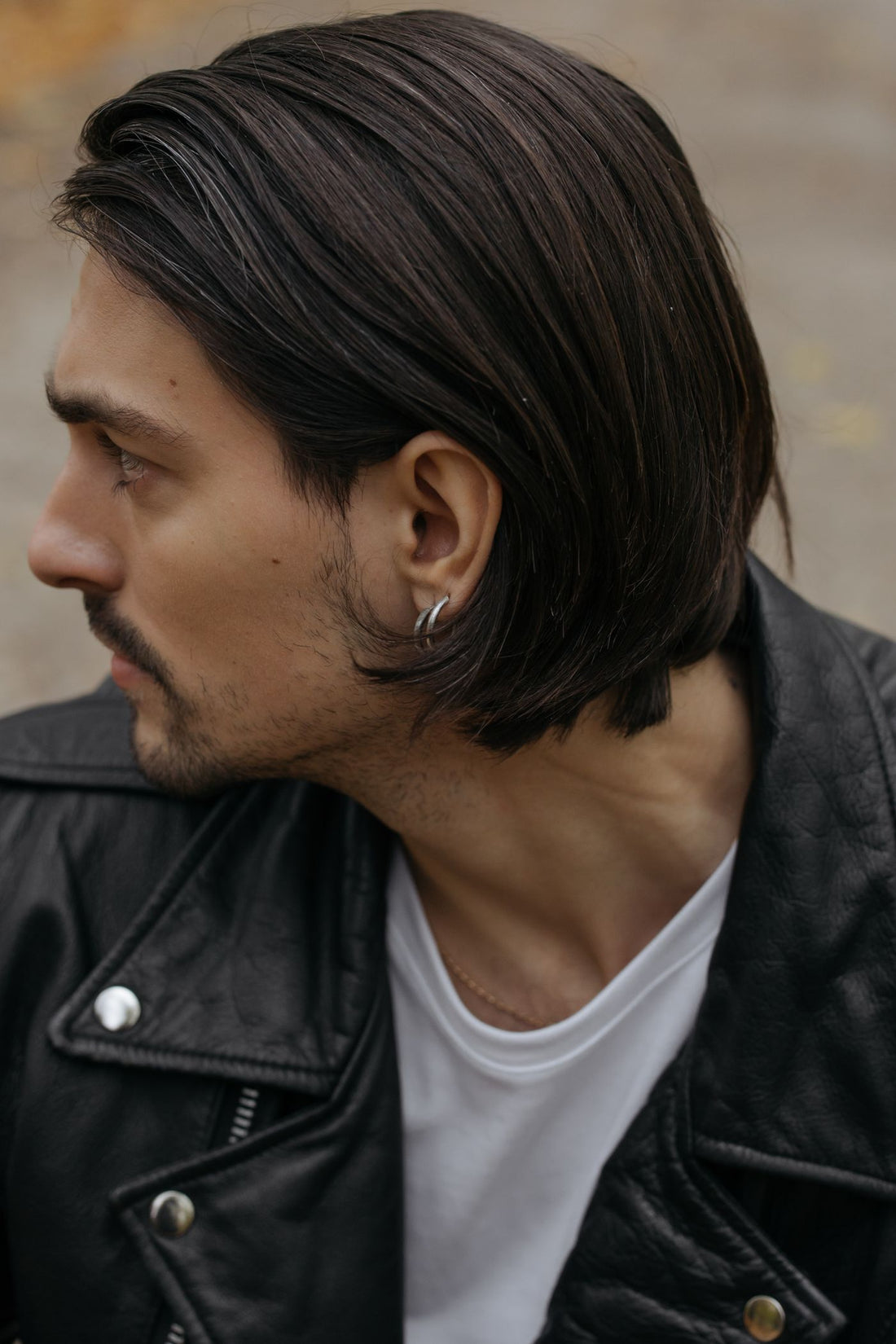 Model in a leather jacket wearing small hoop earrings for a downtown streetwear look
