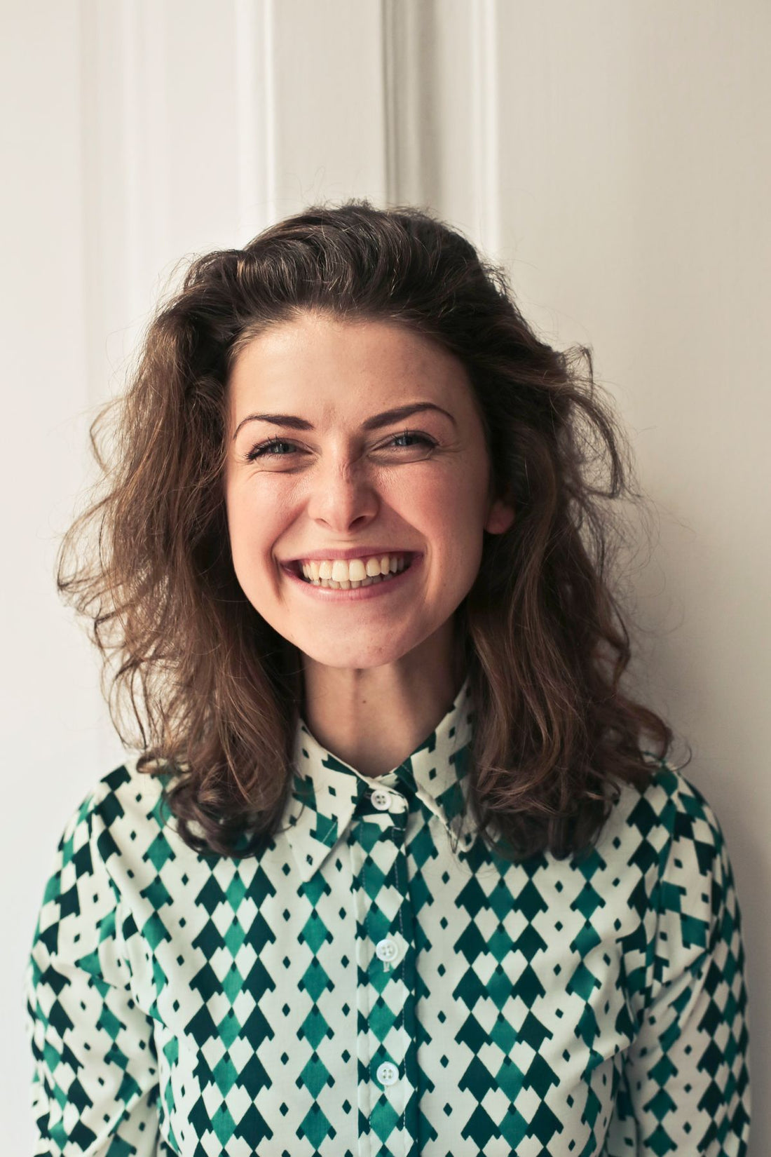 Smiling woman in a patterned shirt for a weekend jewelry styling guide