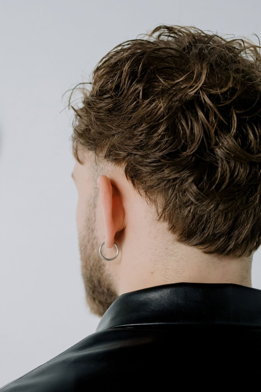 Close-up streetwear portrait of a model with hoop earrings and a bold layered look