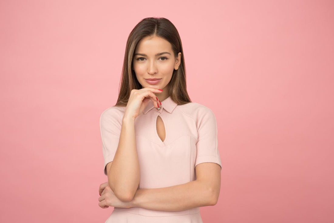 Woman in a soft pink top for a clean gold ring stack styling guide