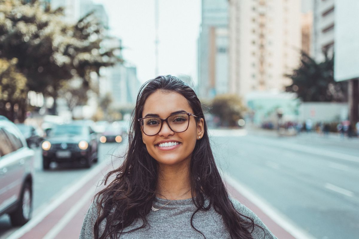 Woman wearing glasses on a city street for an everyday ear jewelry styling guide