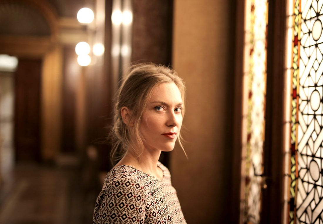 Woman in warm indoor light for a printed top and silver jewelry styling guide