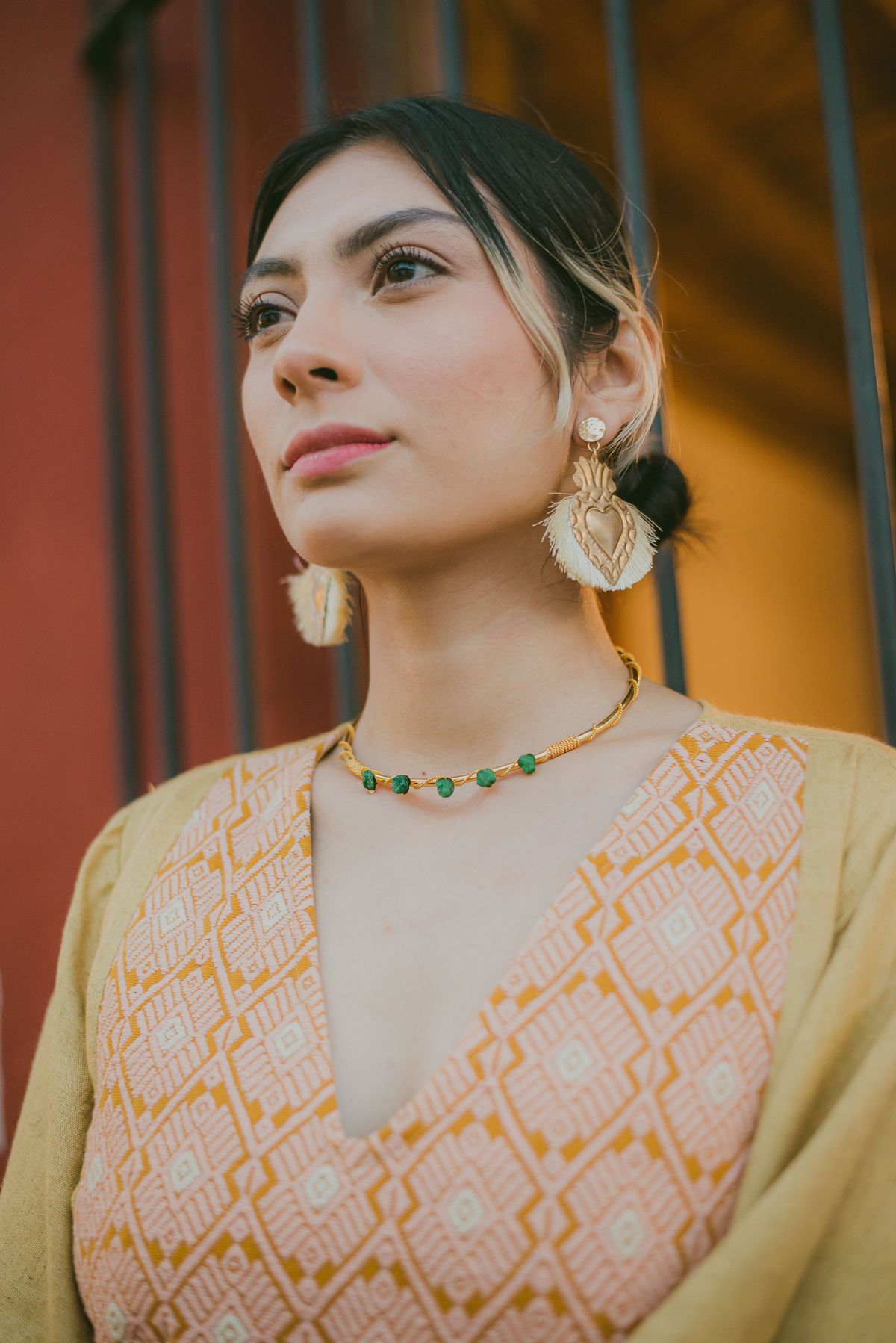 Woman in a lime dress wearing gold earrings outdoors