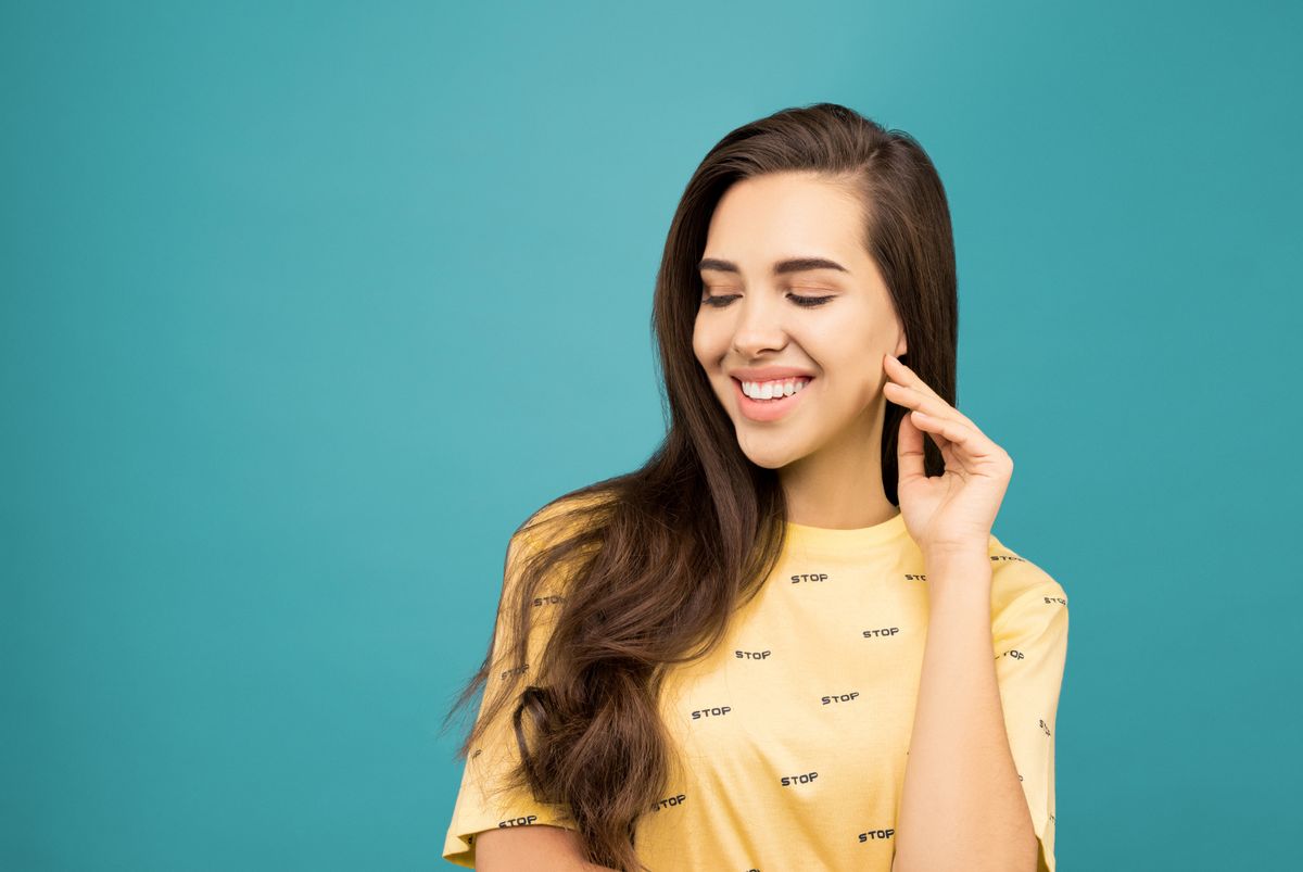 Smiling woman in a yellow tee for a clean color-pop jewelry styling note