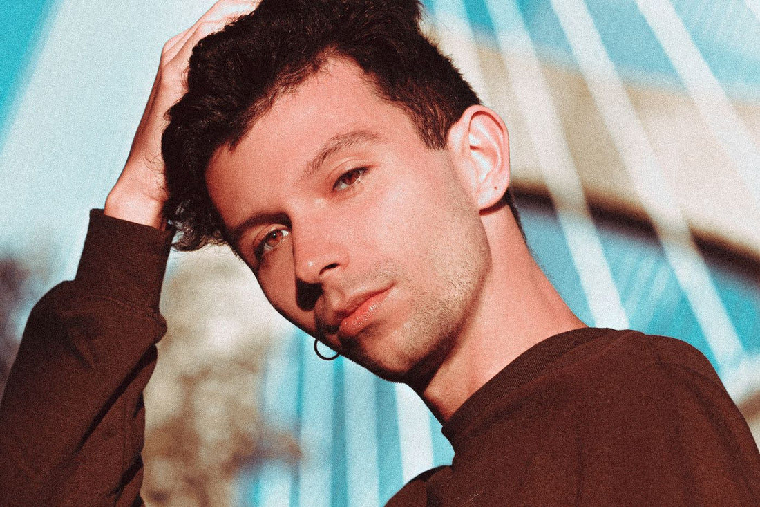 Streetwear portrait of a young man with ear jewelry and a relaxed city outfit