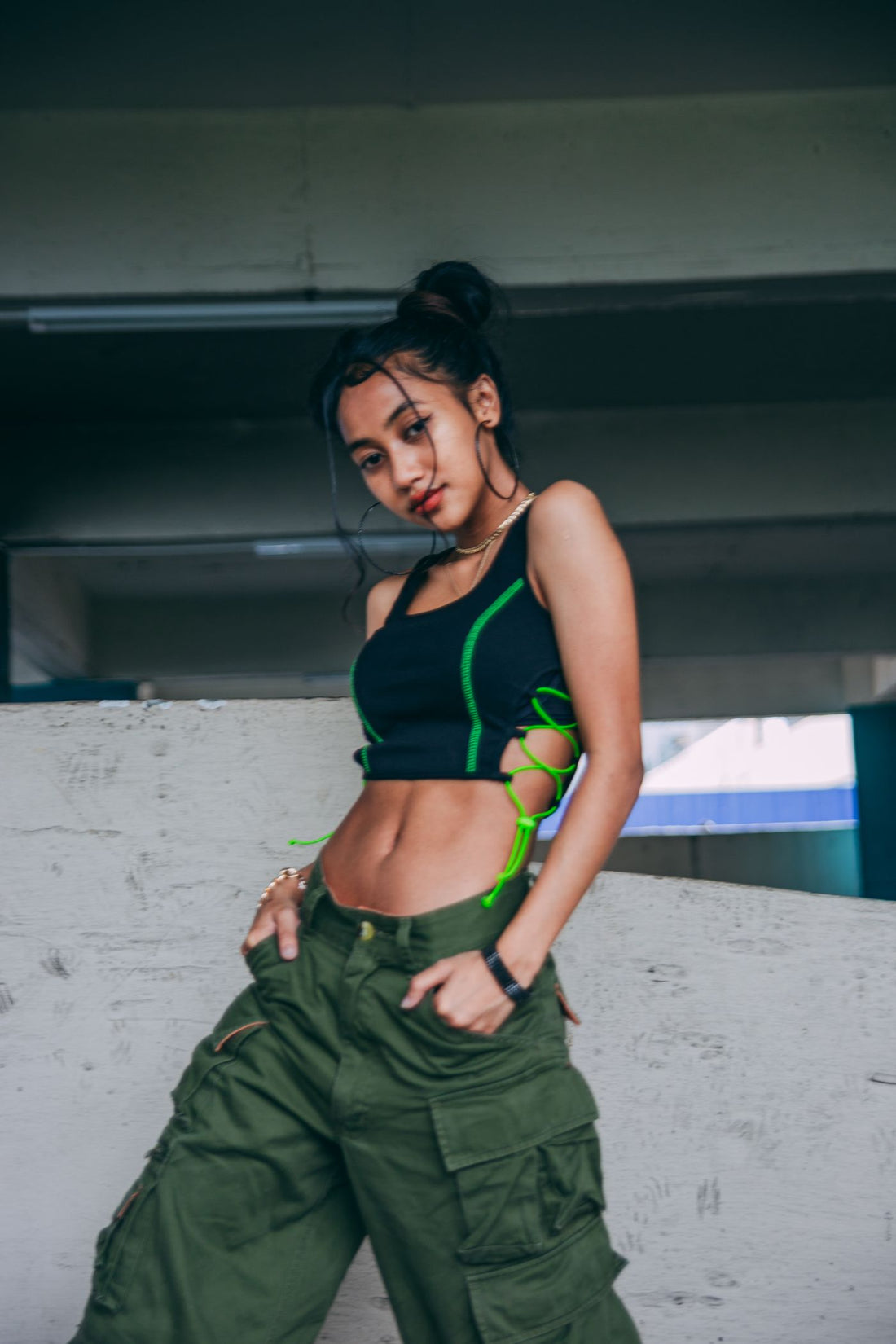 Woman in black top and cargo pants wearing hoop jewelry details