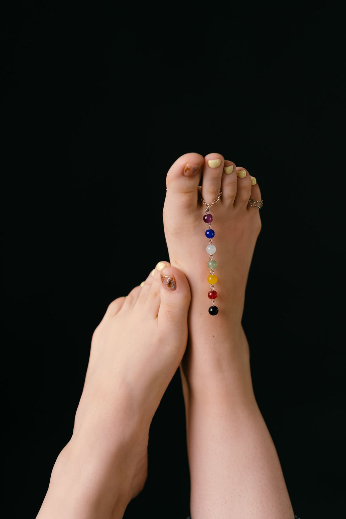 Lifestyle photo of summer foot jewelry styling with polished feet and delicate rings