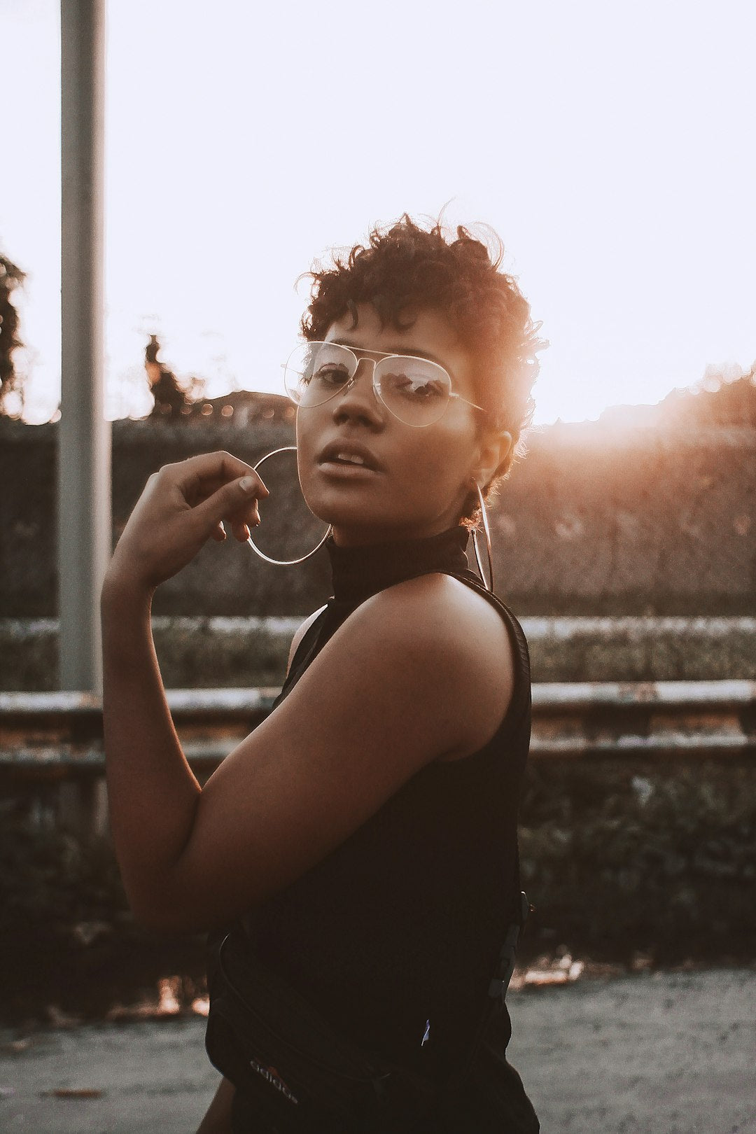 Sunset outfit inspiration with a black sleeveless top and large hoop earrings